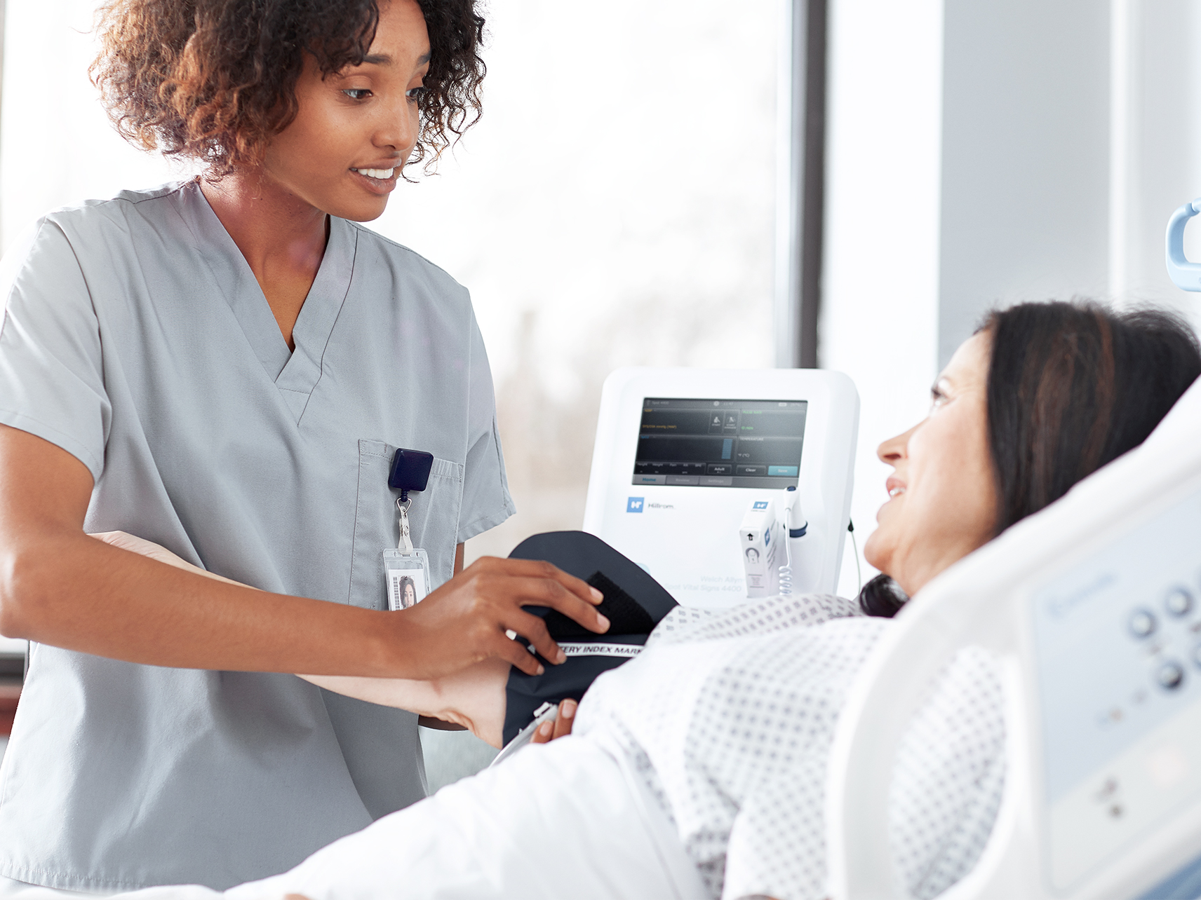 Caregiver taking a patient's blood pressure 